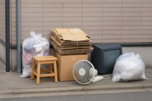 粗大ごみとして出された家具や家電が集合住宅のごみ集積所にまとめられている様子