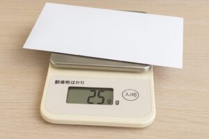郵便物用のデジタルスケールで封筒の重さを測っている様子